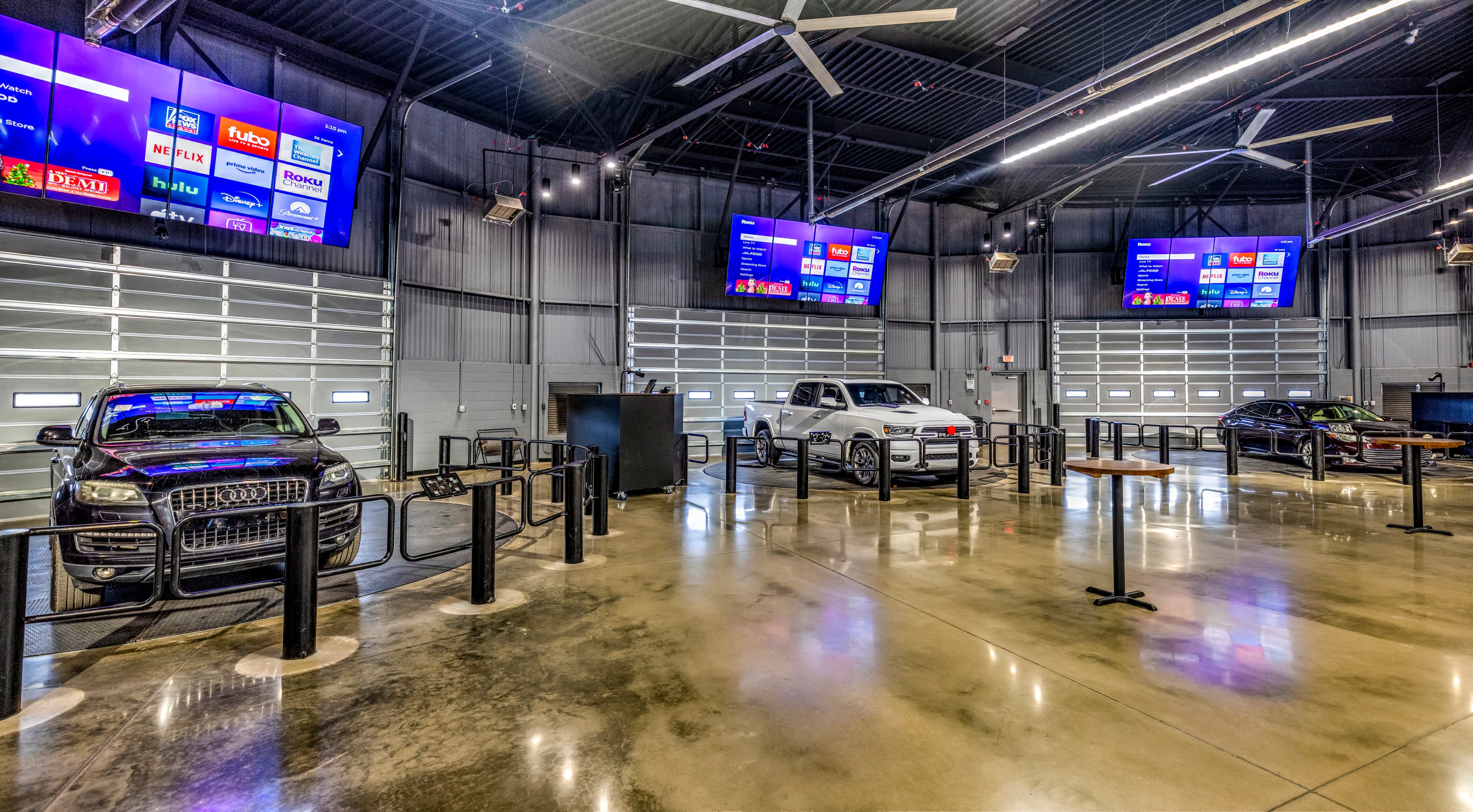 Vehicles on the turntable with the sale shown on overhead screens for online buyers